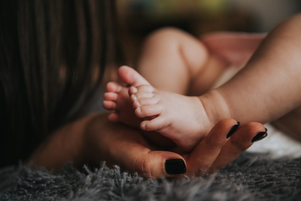 infants-feet-being-held-by-a-womans-hand-with-painted-and-manicured-hands-resting-on-a-gray-blanket-s8bw-wx9g8i Momma’s support your future