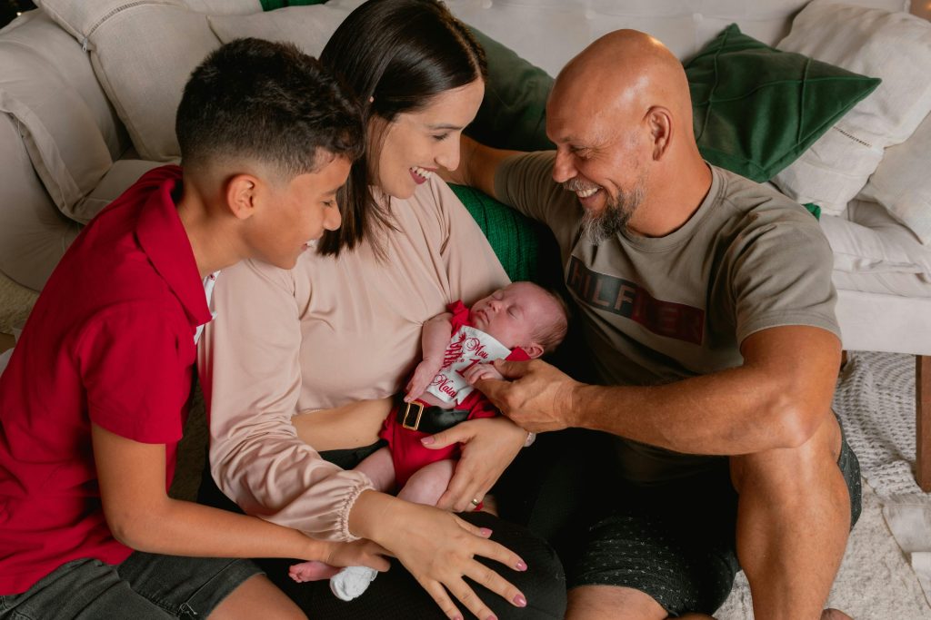 pexels-photo-30701845-30701845 A joyful family sharing a special moment with their newborn baby in a cozy indoor setting.